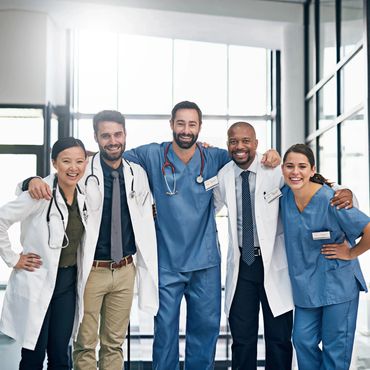 Group of diverse medical professionals smiling together in a hospital.