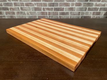 Rebel 77 is a Mahogany and Maple premium EDGE grain cutting/serving board 17 1/2" x 12" x 1"