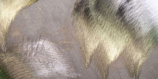 Close-up of a textured metallic surface with brushed gold and silver tones.