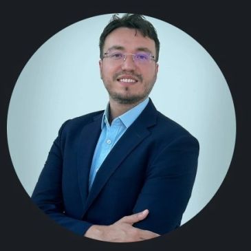 Professional man in glasses and suit smiling confidently.