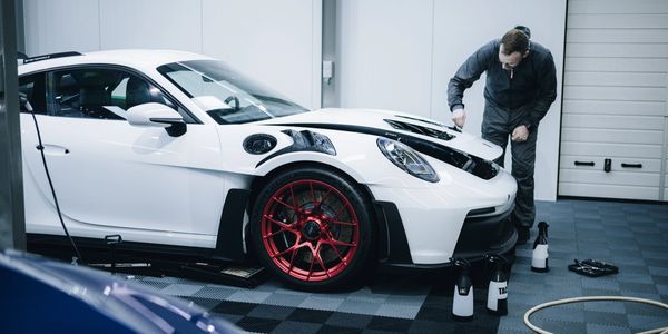 White sports car being detailed inside shop. 