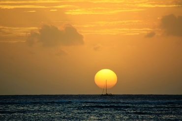 Sailboat at sunset on the ocean.