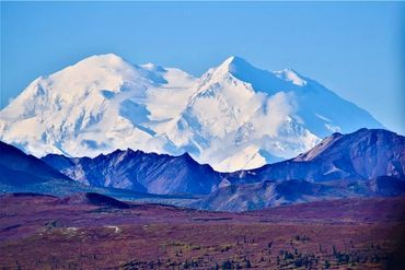 Snow-covered mountain peak with clear blue sky.