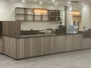 Commercial coffee shop area fitted. Wooden slats, shelving units and marble top installed.