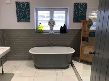 Free standing Bathtub, grey tiles and marble effect flooring laid