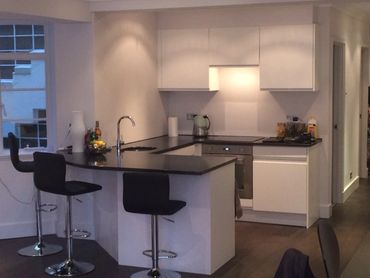 Small unique kitchen space fitted with bar stools and cooking area