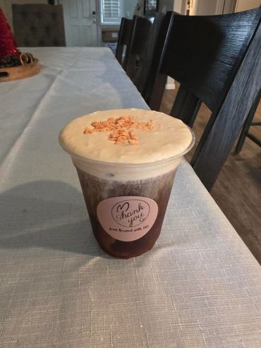 A creamy iced coffee drink with a thank you sticker on the cup.