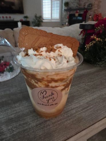 Creamy dessert topped with whipped cream and a large biscuit.