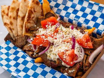 Gyro with pita bread on checkered paper.