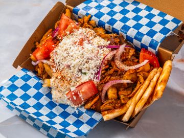 Greek gyro platter with fries and toppings.