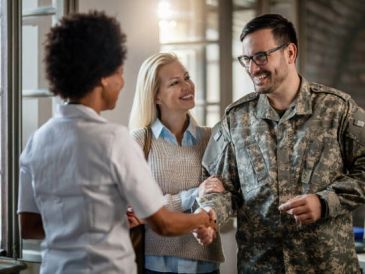 Military man shaking hands with a woman.