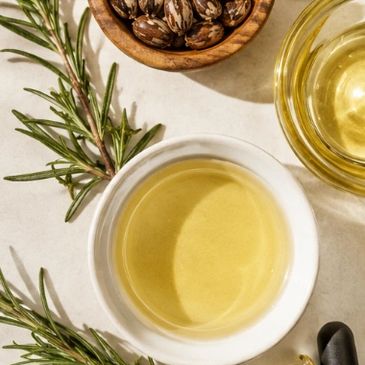 Bowl of yellow oil with herbs and seeds.