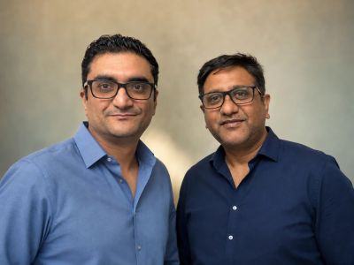 Two men wearing glasses and blue shirts.