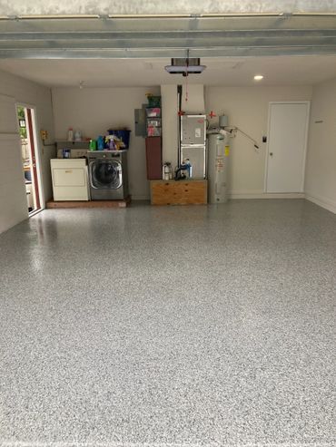 Clean garage with washer, dryer, and water heater.