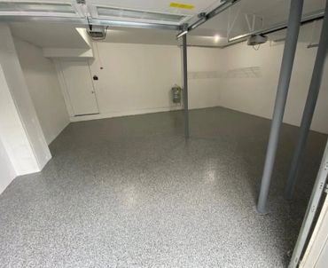 Empty garage with polished epoxy floor and gray support beams.