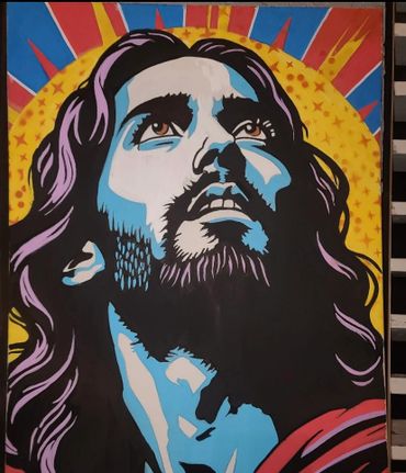 Colorful pop art style painting of a bearded man looking upward with a radiant yellow halo.
