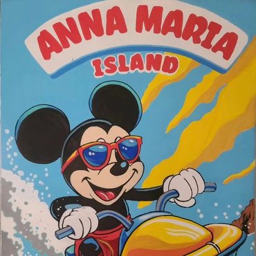 Mickey Mouse rides a jet ski on Anna Maria Island, wearing red sunglasses and smiling.