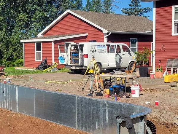 Douthwright Pools work van unloading for another day at work. Digging a pool is pictured.