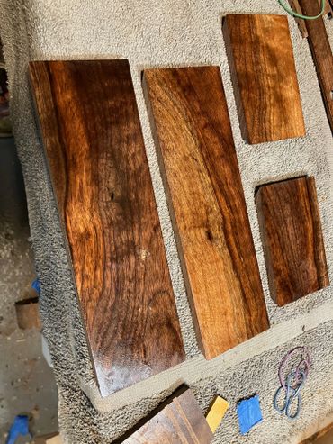 Polished wooden planks with rich grain patterns on a textured surface.