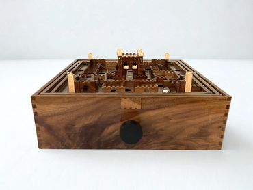 Wooden castle maze game with metal ball and knob.