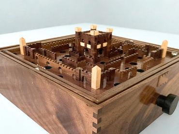 Intricately crafted wooden castle-themed labyrinth puzzle with a rotating knob.