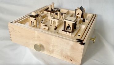 Intricate wooden mechanical maze puzzle with architectural elements and a winding path.