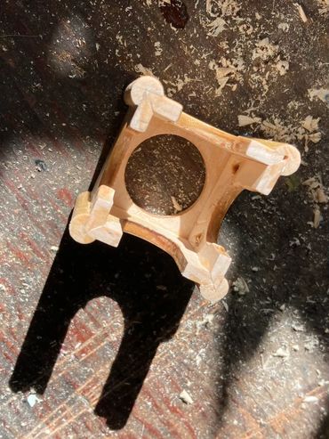 Wooden woodworking piece casting a shadow on a workbench.