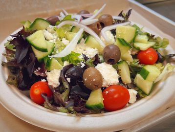 greek salad with lettuce, feta cheese, greek olives, tomato, cucumber and red onion