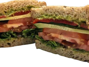 Veggie sandwich with roasted red peppers, lettuce, tomato, cucumber and guacamole