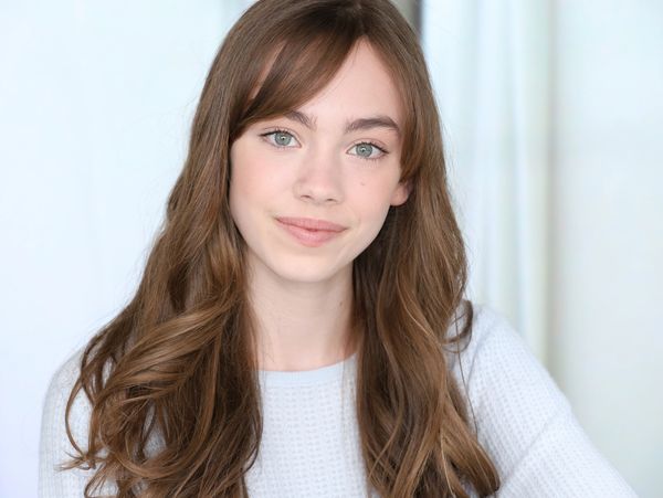 Young woman with long brown hair and a gentle smile.