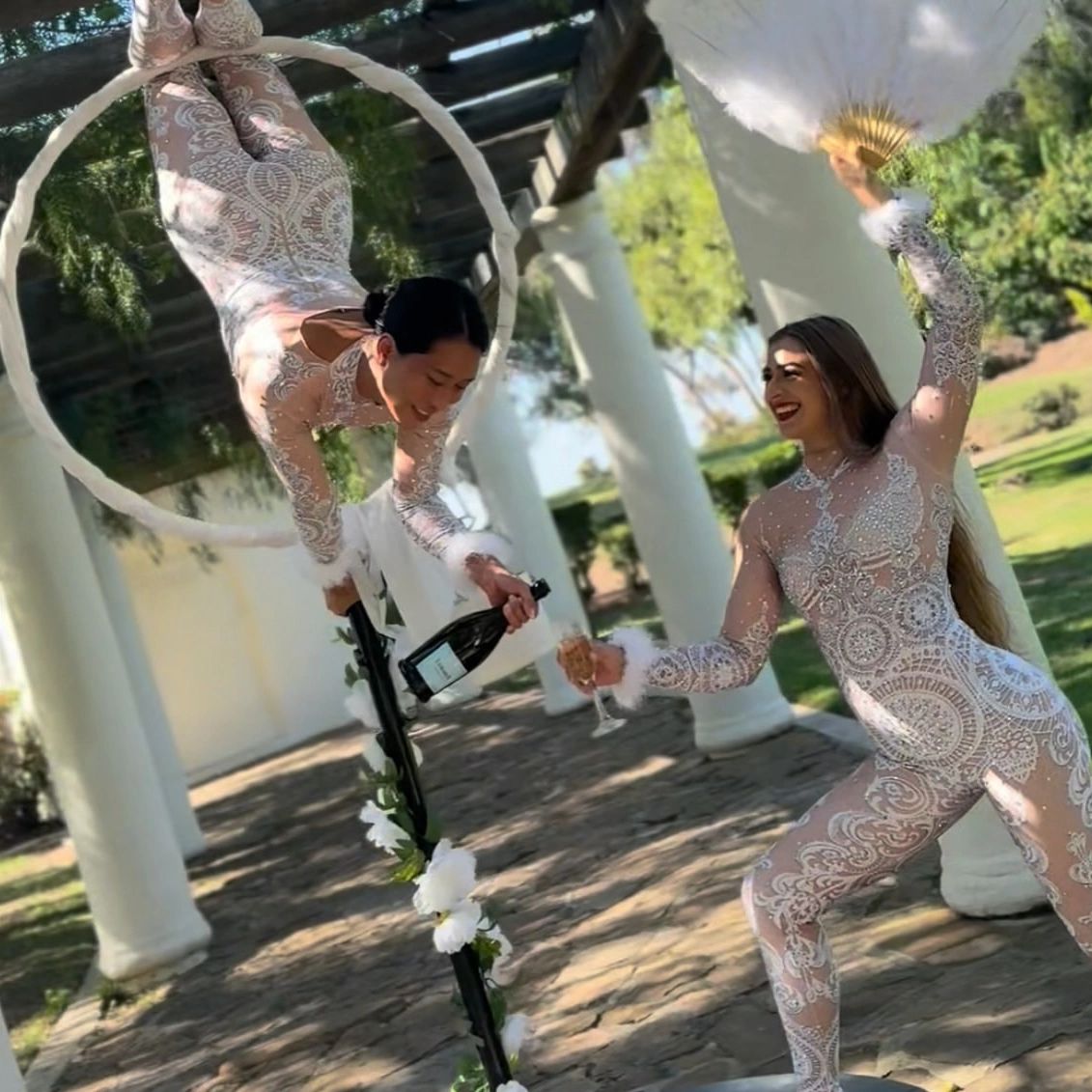 Aerial champagne bartending at an outdoor San Diego wedding with two professional aerial performers