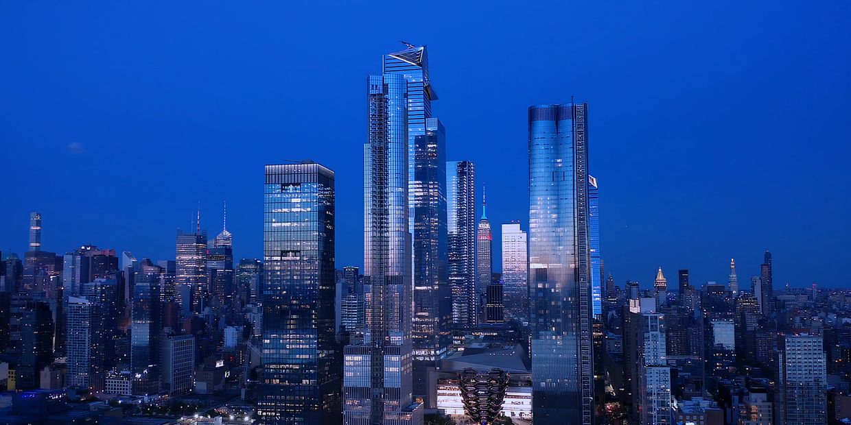Nighttime city skyline with illuminated skyscrapers.