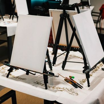 Blank canvases on easels ready for painting.