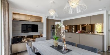 Modern kitchen and dining area with neutral tones and sleek design.