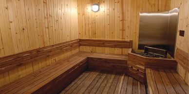 Wooden, warmly lit dry sauna room, quintessential part of the Korean spa & sauna experience