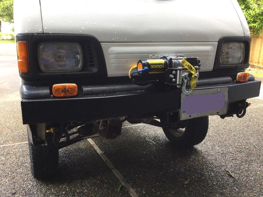 Front view of a vehicle with a mounted 3000 lb winch on the bumper.