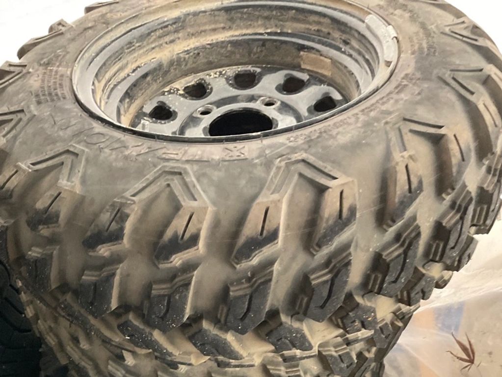 Close-up of a rugged off-road tire with deep tread patterns.