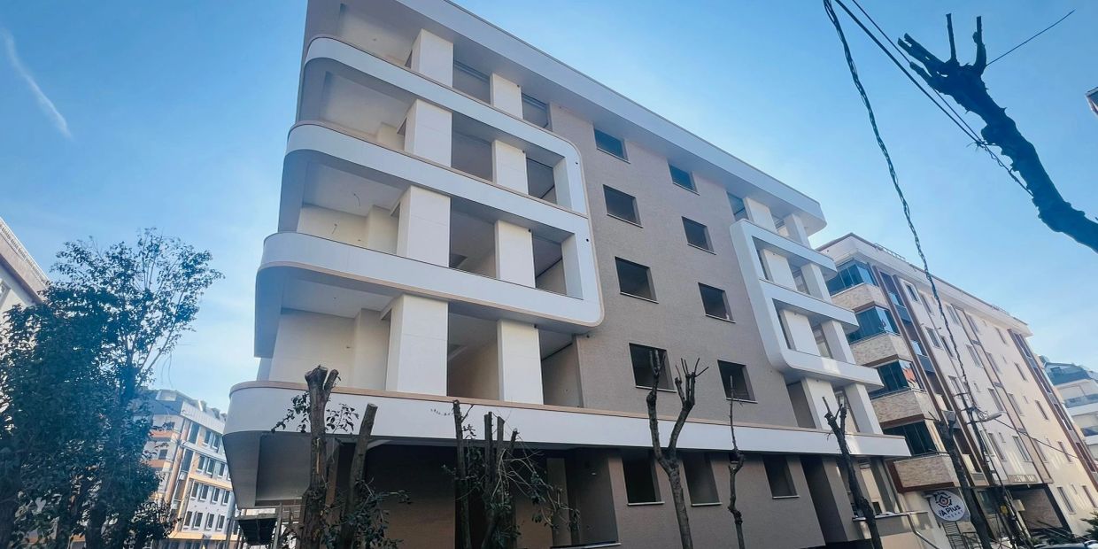 Modern apartment building with unique white balcony designs against a clear blue sky.
