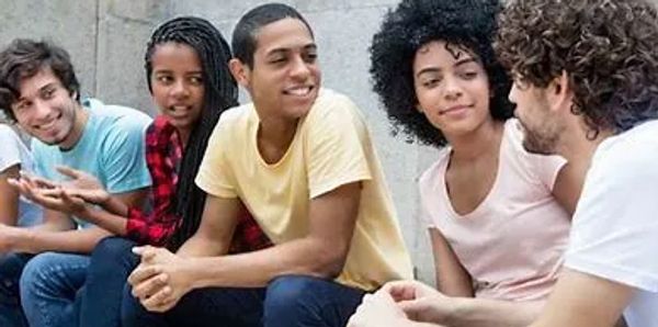 A group of five young adults engaged in a friendly conversation.
