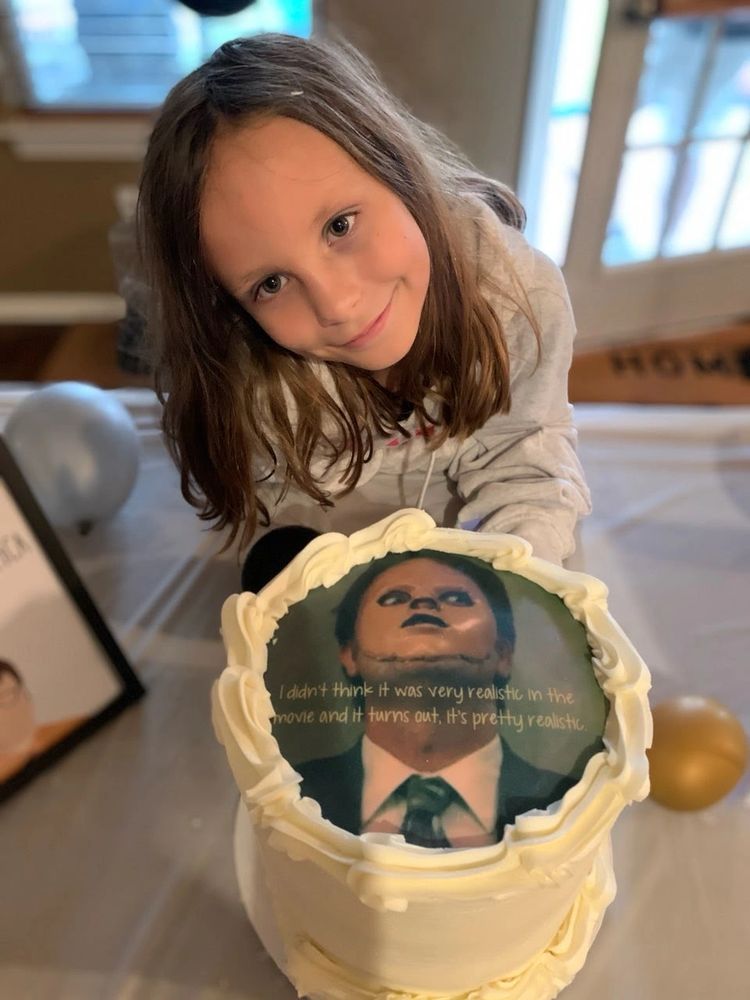 Kid holding a cake from "The Office"