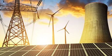 Energy sources including solar panels, wind turbines, power lines, and a cooling tower at sunset.