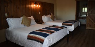 Cozy room with two neatly made beds and warm wooden accents.