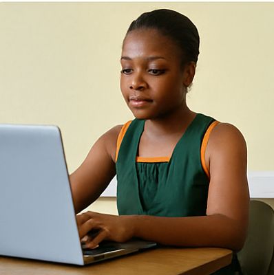 Young woman focused on her laptop work at a desk.