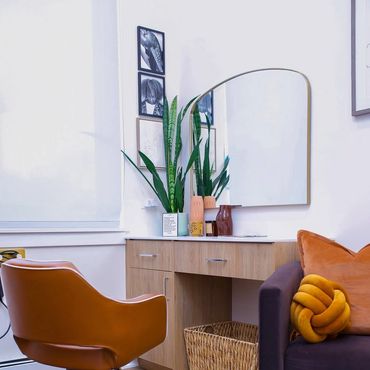 Cozy corner with a brown chair, wooden desk, and decorative plants.