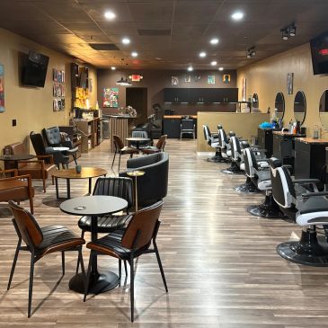 Modern barbershop with chairs and tables.