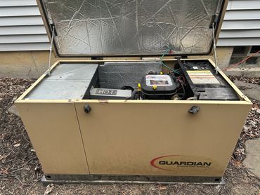 Outdoor Guardian generator with open lid showing engine and components.