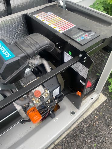 Close-up of a Siemens-powered Generac generator engine with labels and control panel.