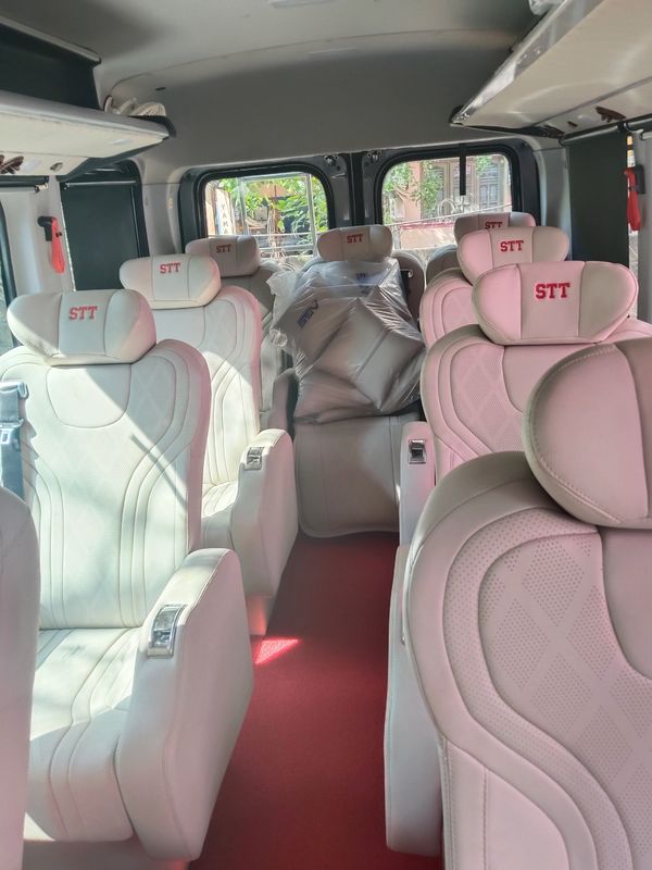 Force Urbania Van -Luxurious white leather seats inside a van with red carpeting.