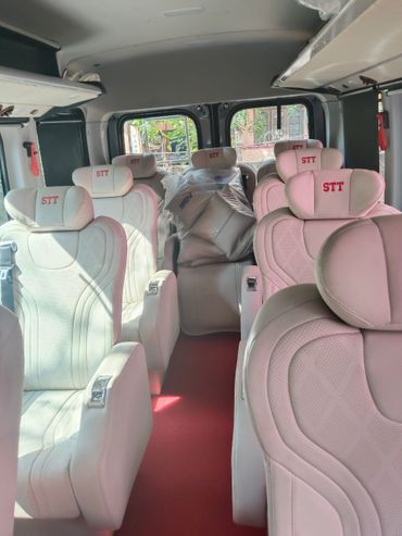 Force Urbania Van rent in bangalore Luxurious white leather seats inside a van with red carpeting.