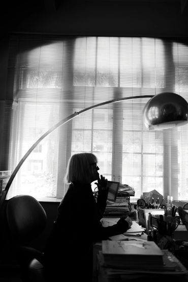 Black and white silhouette of elderly woman at desk